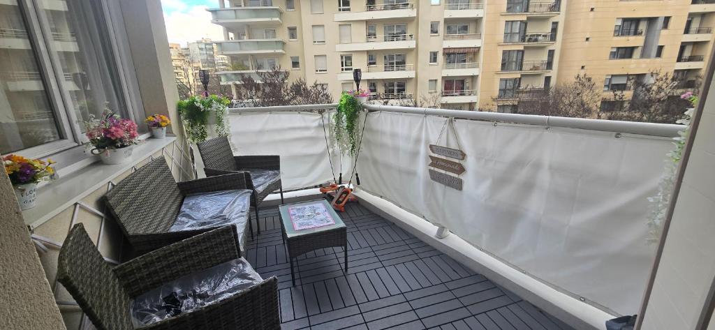 a balcony with chairs and a table on a building at Suite Prestige Paris-La Défense Balcon-Terrasse in Courbevoie