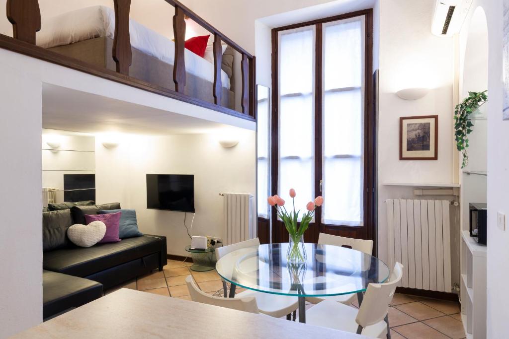 ein Wohnzimmer mit einem Glastisch und einer Couch in der Unterkunft Monte Nero UP&DOWN in Mailand