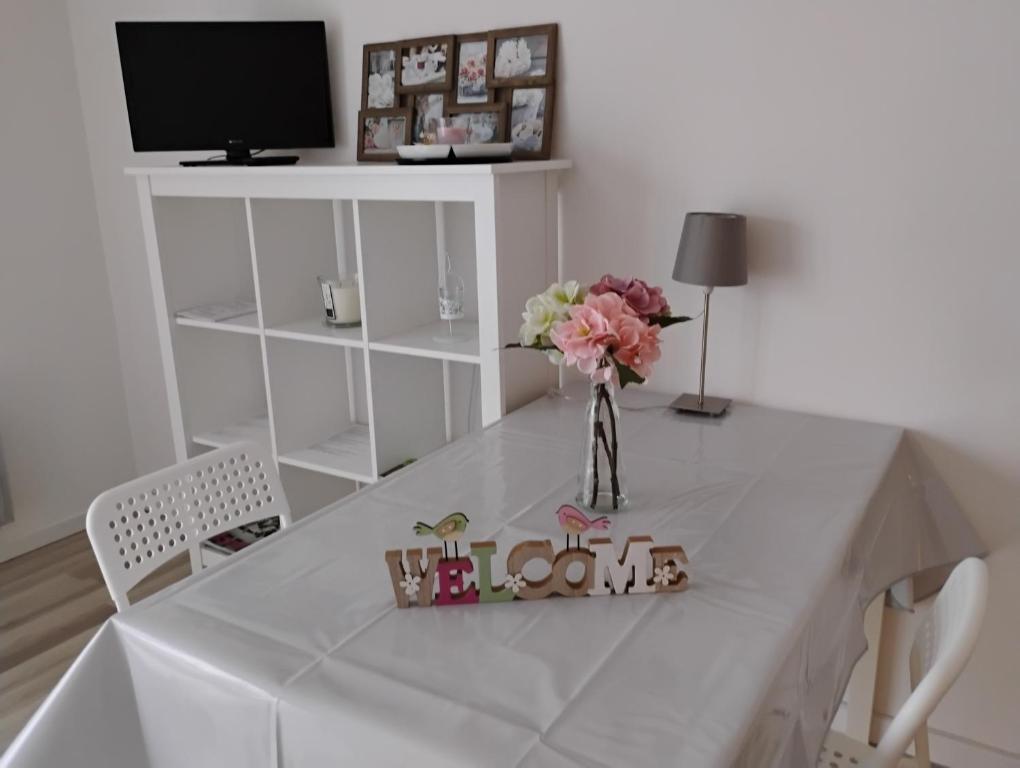 une table blanche avec un vase de fleurs sur elle dans l'établissement LE COSY STRASBOURGEOIS tram à 2' et GARE ou CHU Hautepierre à 5', à Strasbourg