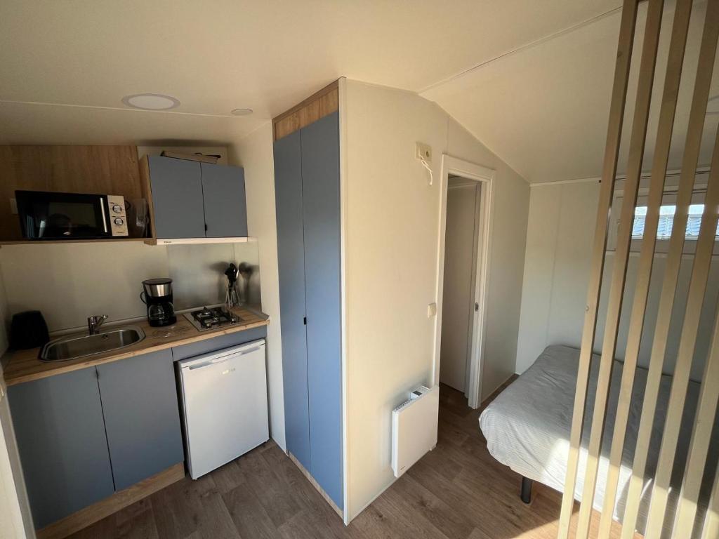 une petite cuisine avec un évier et un lit dans l'établissement Studios au camping, à Saint-Martin-Plage