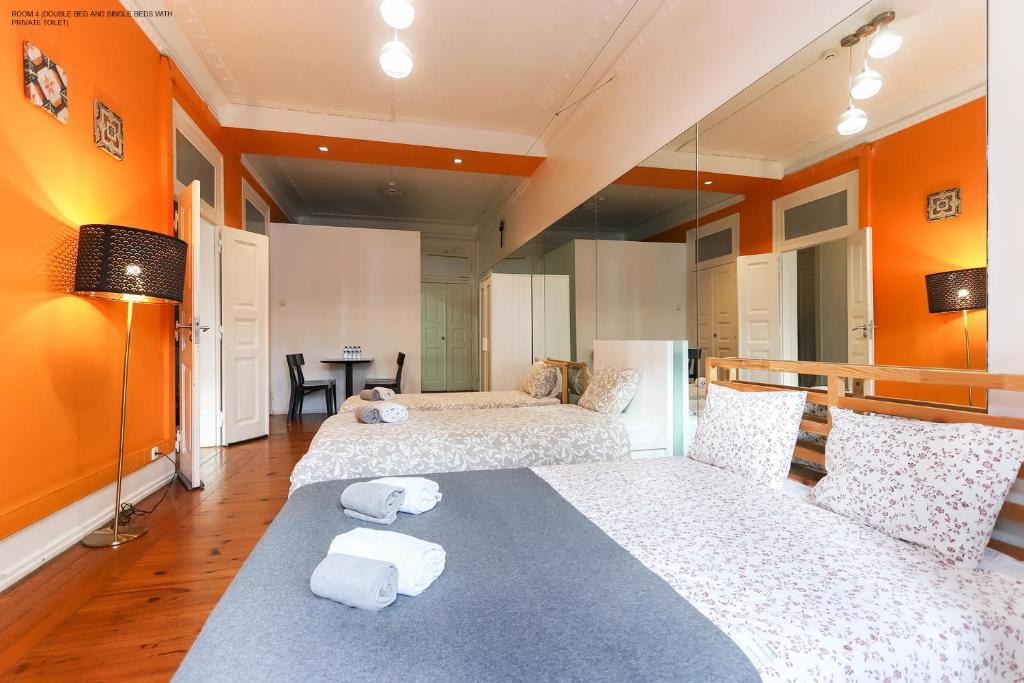 two beds in a room with orange walls at Lisbon Garden Flower in Lisbon