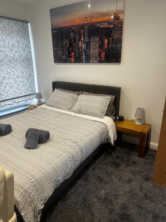 a bedroom with two beds and a picture on the wall at Town Centre Cosy Flat in Merthyr Tydfil