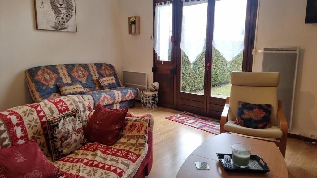 een woonkamer met een bank en een tafel bij Chez Mady - Terrasse, Vue Montagne & Proche Ski in Bussang