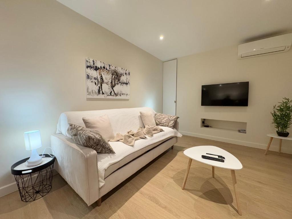 un salon avec un canapé blanc et une télévision dans l'établissement Le studio Palm Beach, Clim ,Parking, Neuf, à Cannes