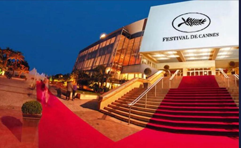 une femme marchant sur un tapis rouge devant un bâtiment dans l'établissement Jo Malone, à Cannes