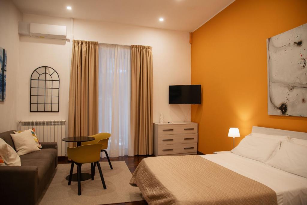 une chambre d'hôtel avec un lit et un canapé dans l'établissement HELLO CHIAIA NAPOLI by Progecta srl, à Naples