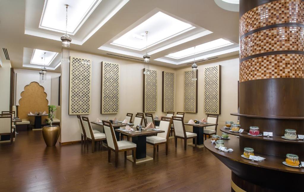 a restaurant with tables and chairs in a room at Western Hotel - Madinat Zayed in Madīnat Zāyid