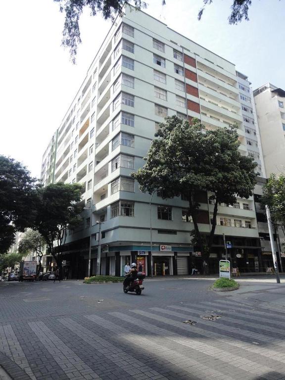 a person riding a scooter in front of a large building at Vagas Carnaval AP no Centro de BH in Belo Horizonte