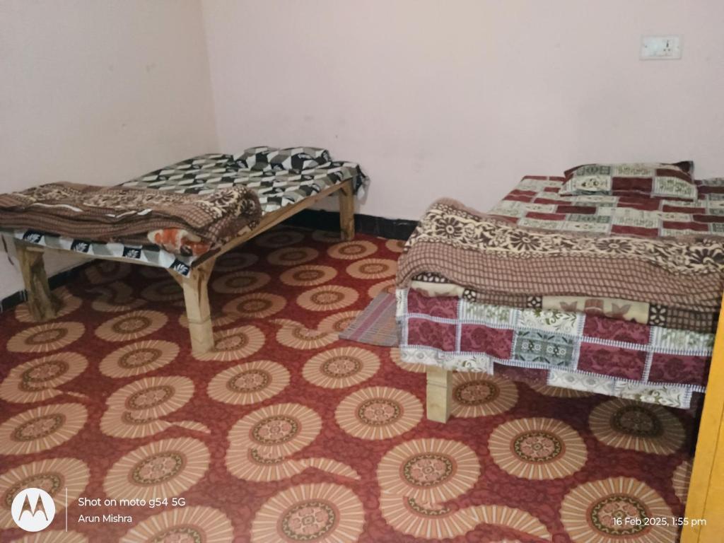 two beds sitting in a room with a carpet at Mahavir home stay in Prayagraj