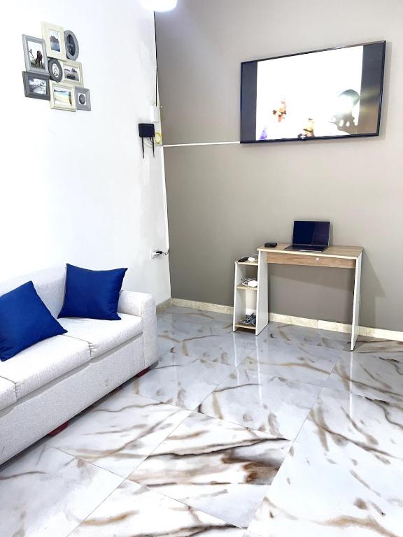 a living room with a couch and a table with a laptop at Casa Eterno Sol B&B in Catamayo