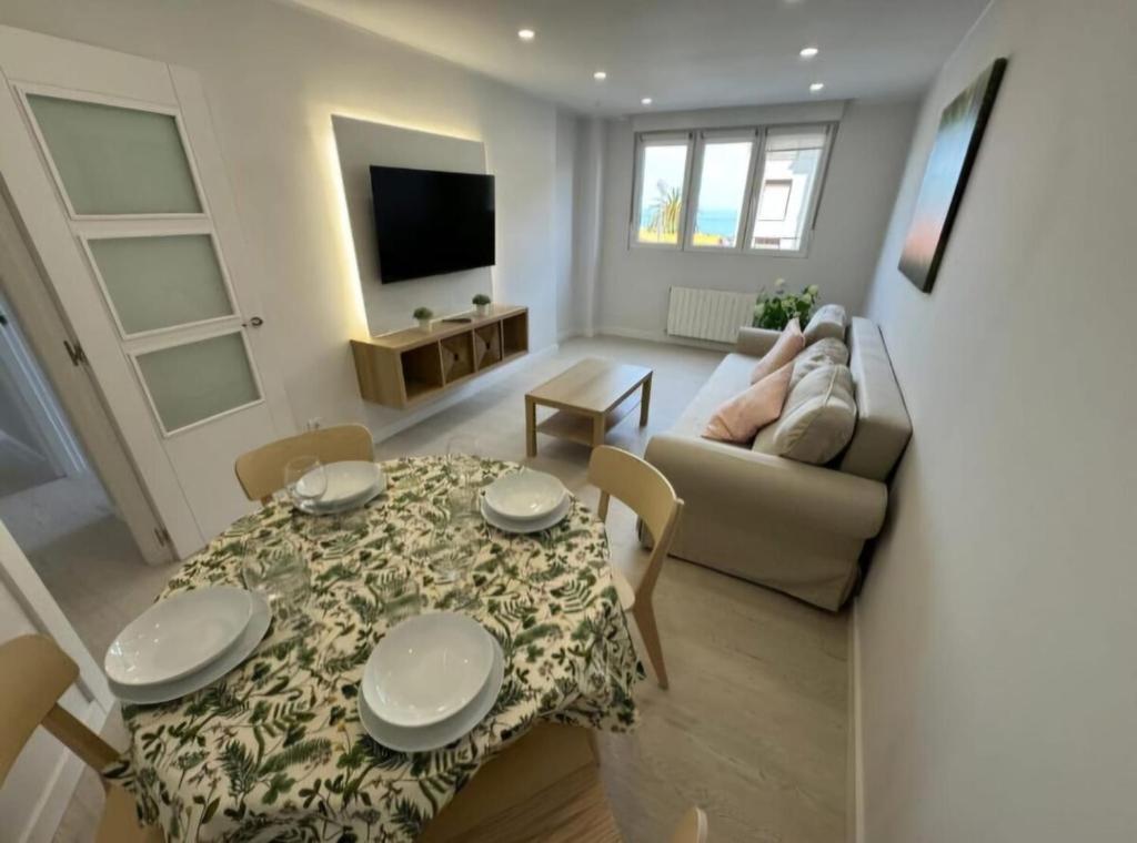a living room with a table and a couch at Apartamento Araceli in Suances