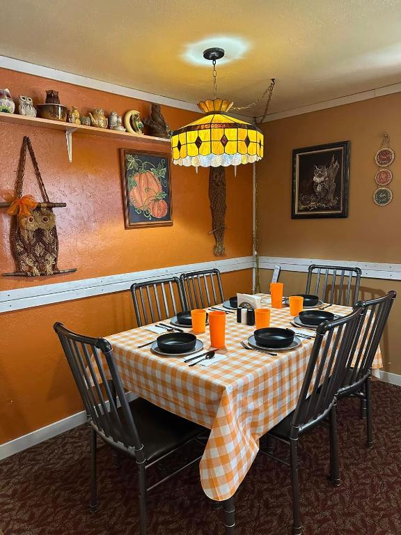 a dining room table with a checkered table cloth on it at EZ 1 mile to Fort Sill! Pumpkin Cottage sleeps 9, grills, firepit, laundry in Lawton