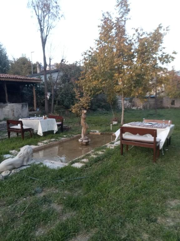 a yard with two tables and a statue in the grass at Han SAFRANBOLU in Safranbolu