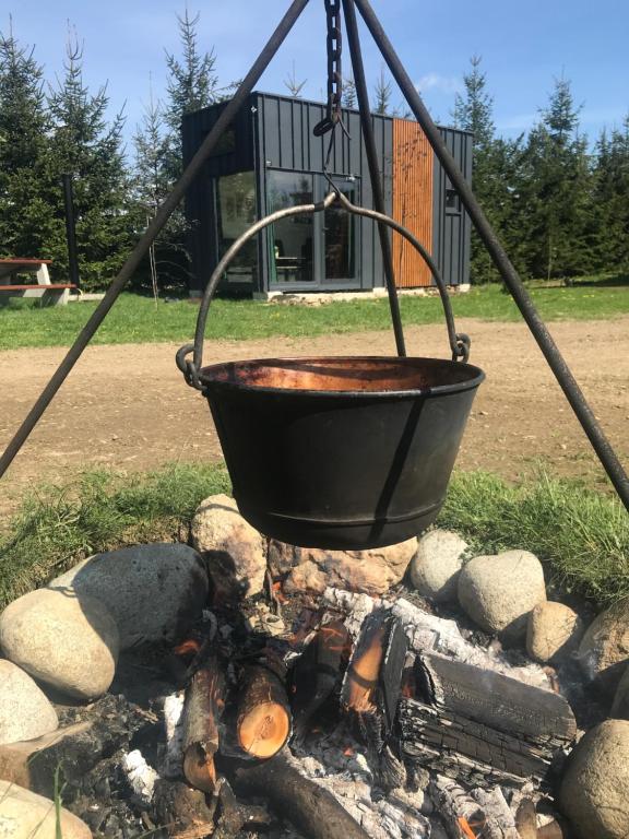a bucket hanging over a fire in a fire pit at TinyHouses & Garden in Oravská Poruba