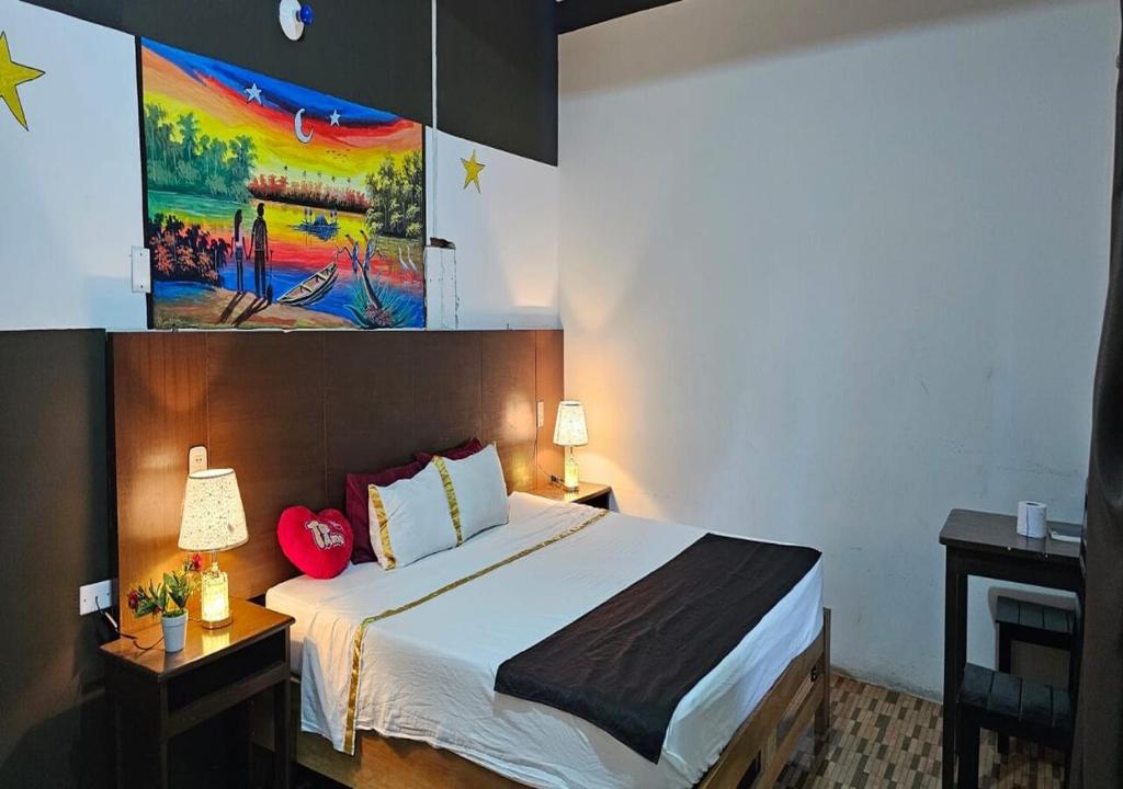 a bedroom with a bed and a painting on the wall at HOTEL LUNA Iquitos in Iquitos