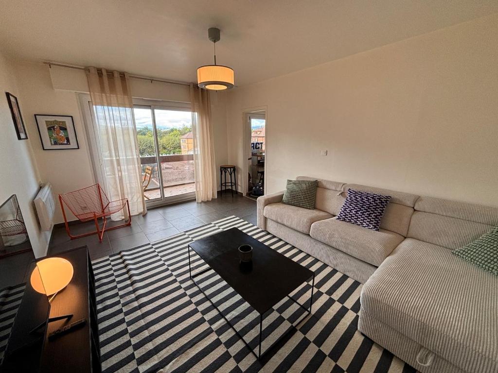 un salon avec un canapé et une table basse dans l'établissement LE POP appartement contemporain avec terrasse et parking, à Bonneville