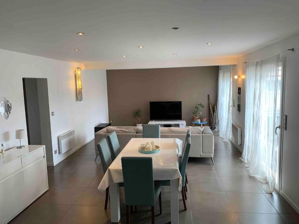 une salle à manger et un salon avec une table et des chaises dans l'établissement Villa bord de mer au Grau d 'Agde 140 m2, au Grau-dʼAgde