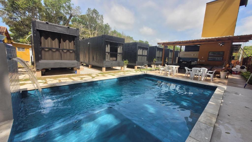 a swimming pool in a backyard with a house at Aldeia Mar in Bertioga