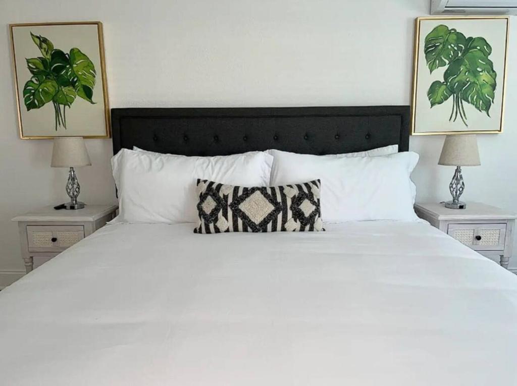 une chambre avec un lit blanc et deux lampes dans l'établissement Fully Fenced With Hot tub near Siesta Key Bridge, à Sarasota