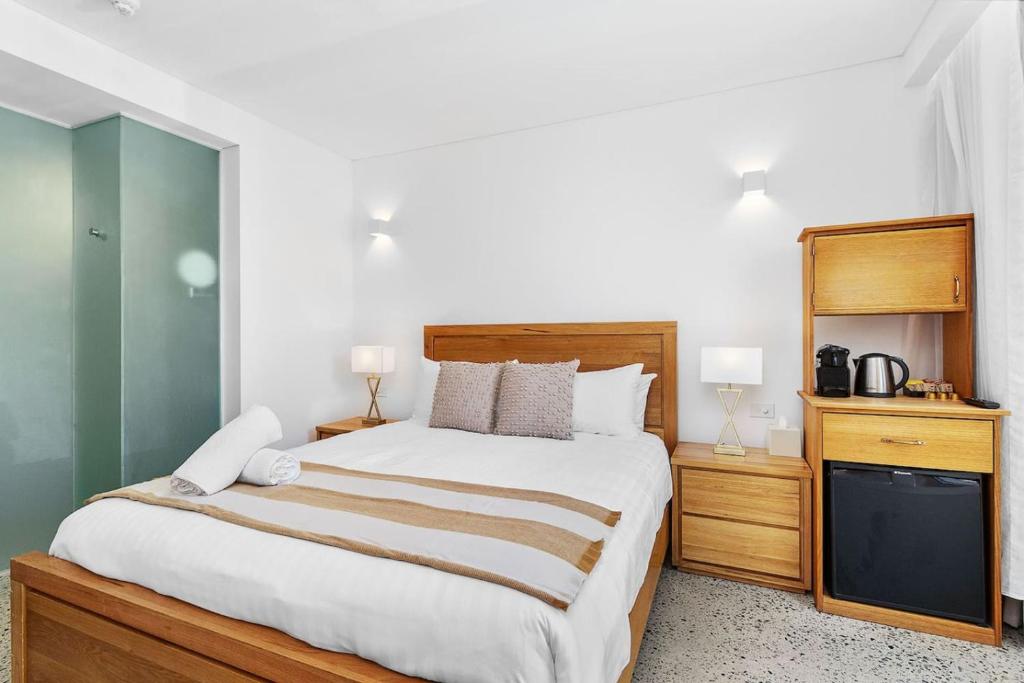 a bedroom with a large bed and a television at Nest on Newcastle - S1 in Perth