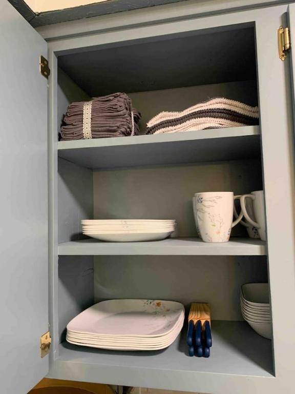 a cupboard with plates and dishes in it at Peaceful APT by Lakebottom w Arcade 8mi Ft Moore in Columbus