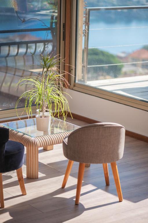 une table et une chaise devant une fenêtre dans l'établissement Bas de villa plus piscine Vue époustouflante, à Villefranche-sur-Mer