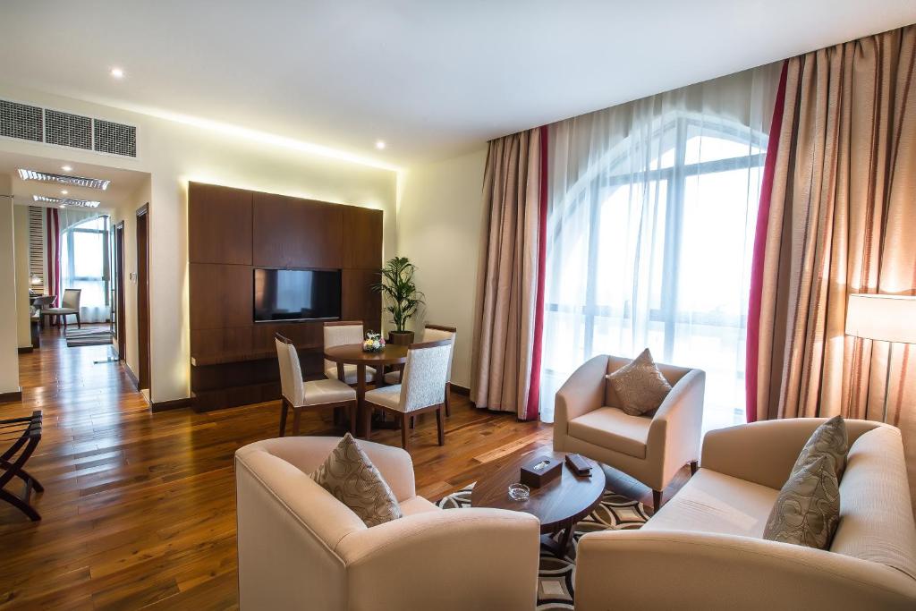 a living room with couches and a dining room at Western Hotel - Madinat Zayed in Madīnat Zāyid