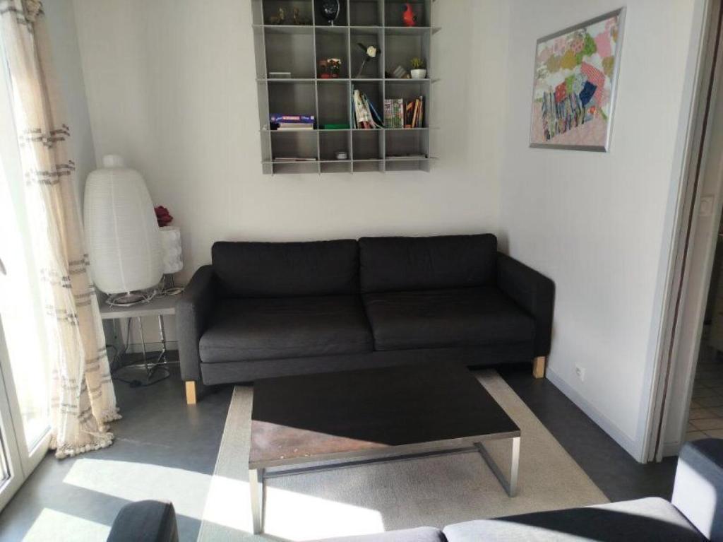 a living room with a black couch and a table at Altitude 1800 - maeva Home - Appartement 4 Pièces 8 personnes - Confort MAE-2791 in La Mongie