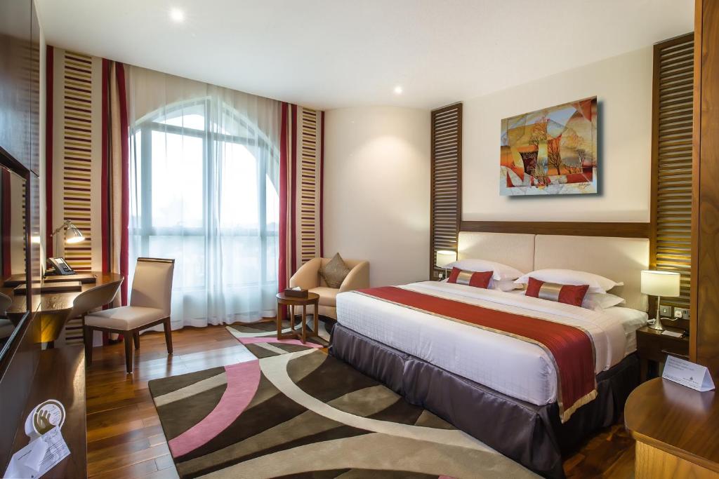 a hotel room with a large bed and a desk at Western Hotel - Madinat Zayed in Madīnat Zāyid