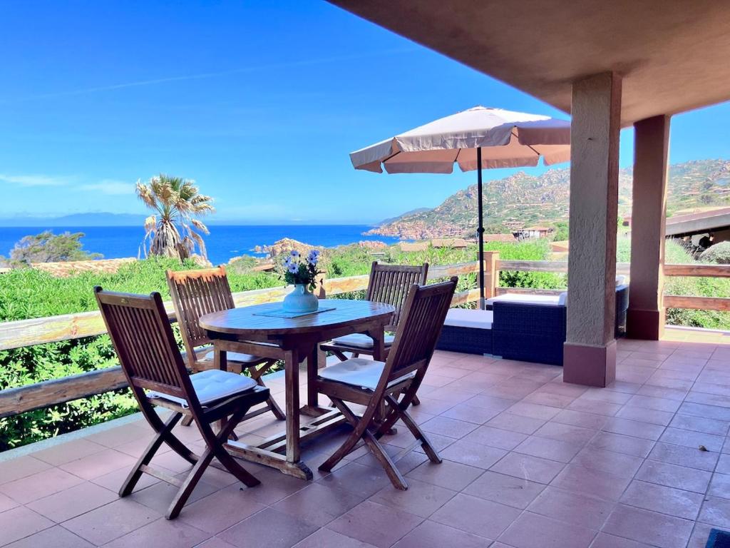 ein Tisch und Stühle auf einer Terrasse mit Blick auf das Meer in der Unterkunft Villa Corallo con vista mozzafiato in Costa Paradiso