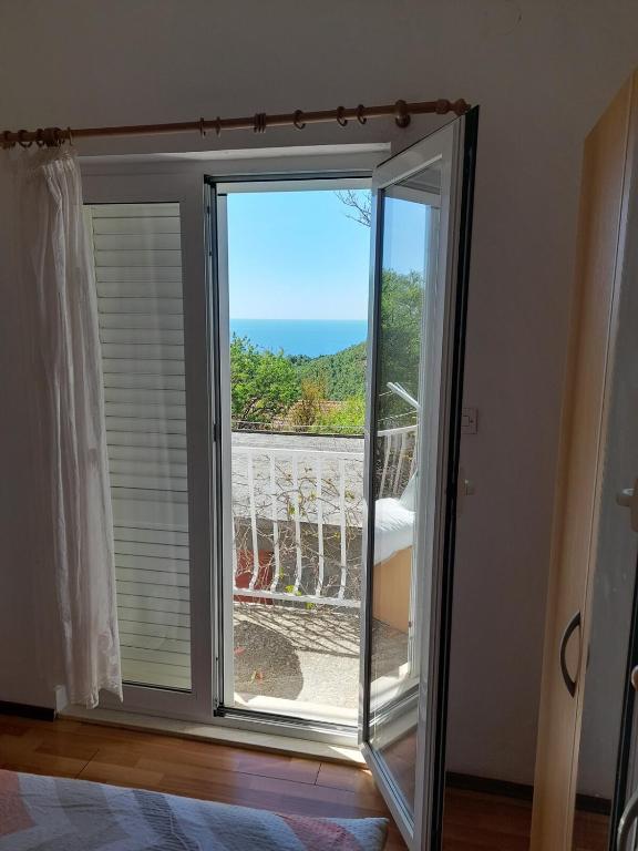 a sliding glass door with a view of the ocean at Marijana - One bedroom with balcony in Babino Polje