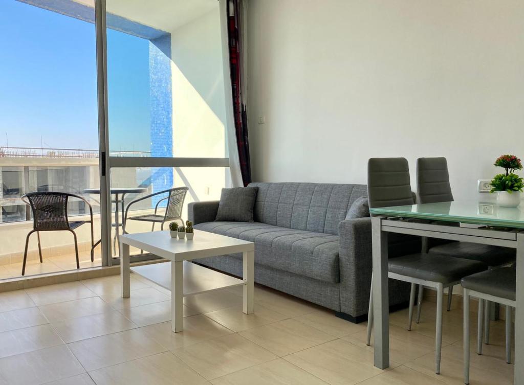 un soggiorno con un divano e un tavolo di bat-yam 2 Bedrooms on the beach a Bat Yam