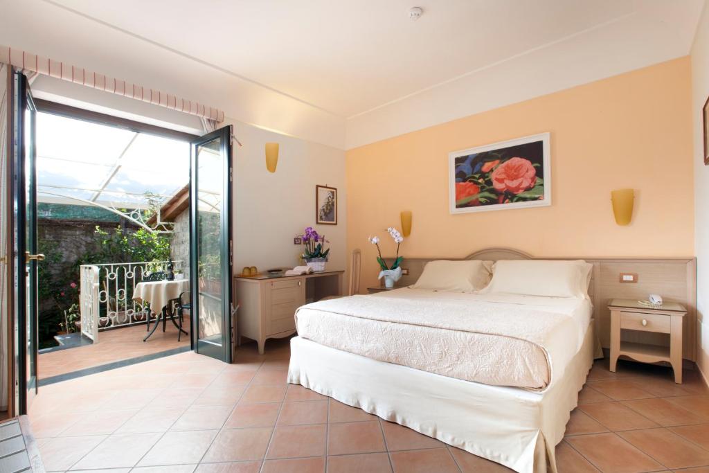 a bedroom with a bed and a balcony at Relais Villa Angiolina in Sorrento