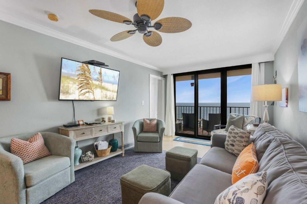 a living room with a couch and a ceiling fan at Phoenix I 1112-11th floor splash pad beachfront in Orange Beach