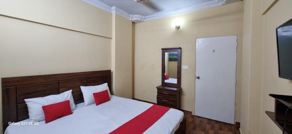 een slaapkamer met een bed met rode kussens en een spiegel bij One Bedroom studio apartment with kitchen in Karachi