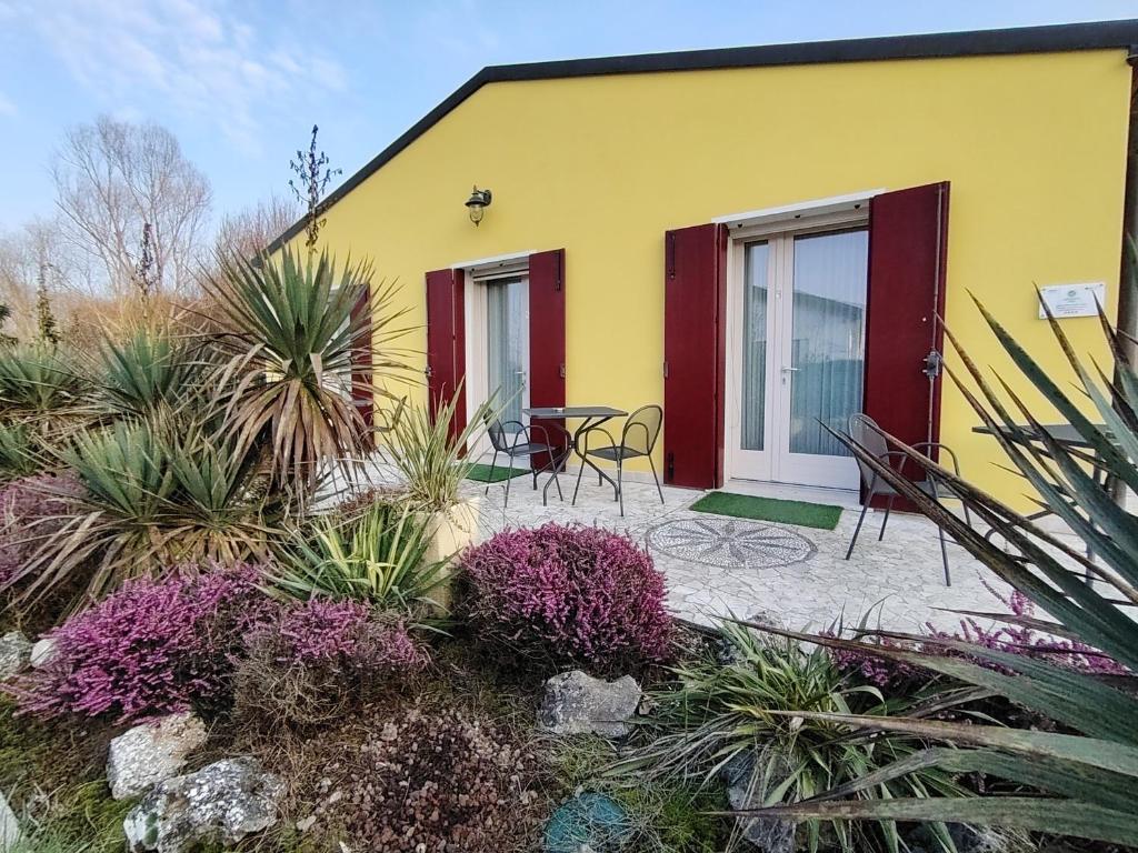 a yellow and red house with a patio with plants at Agriturismo Honey Farm in Piazzola sul Brenta