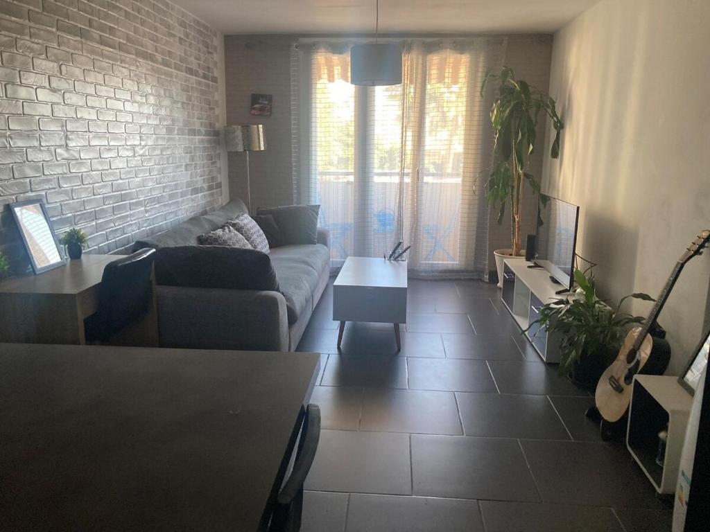 un salon avec un canapé et une table dans l'établissement Appartement cosy proche des plages et commodités, à Nice