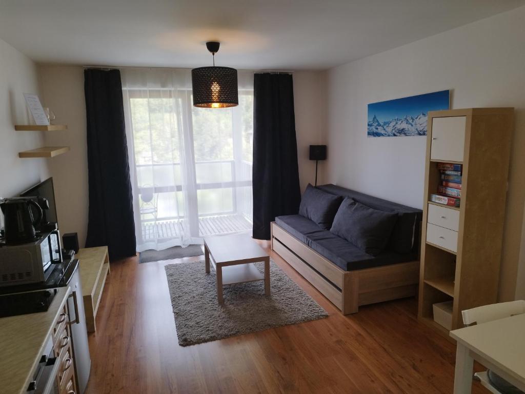 a living room with a couch and a window at Apartmány Liptov MACO in Liptovský Mikuláš