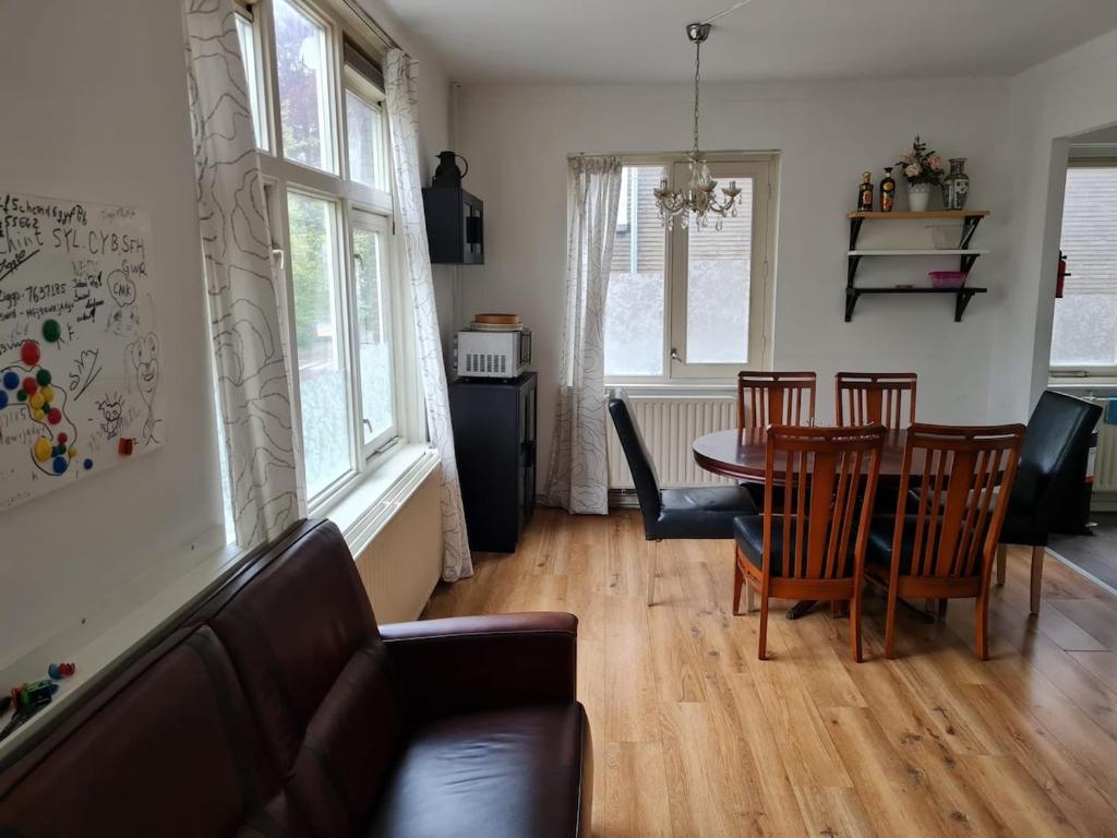 ein Wohnzimmer mit Tisch und Stühlen in der Unterkunft Three bedroom lovely apartment in Oosterbeek