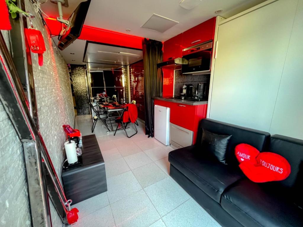 a living room with a couch and a kitchen at Cap Red Room in Cap d'Agde