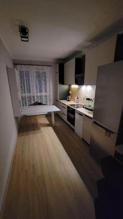 eine Küche mit einem Tisch in der Mitte eines Zimmers in der Unterkunft Illumina nowoczesny apartament 50m2, spokojna okolica, 25min do centrum in Krakau