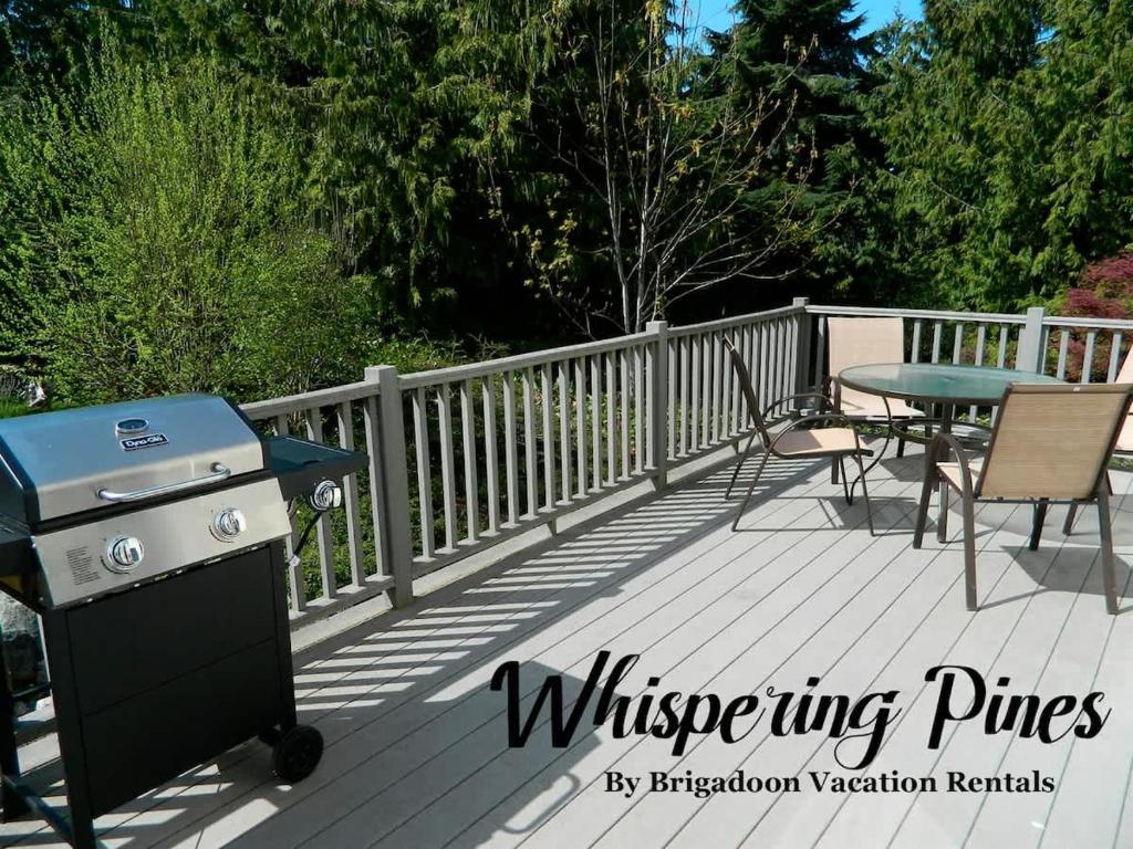 a grill and a table and chairs on a deck at PA Whispering-Pines in Port Angeles