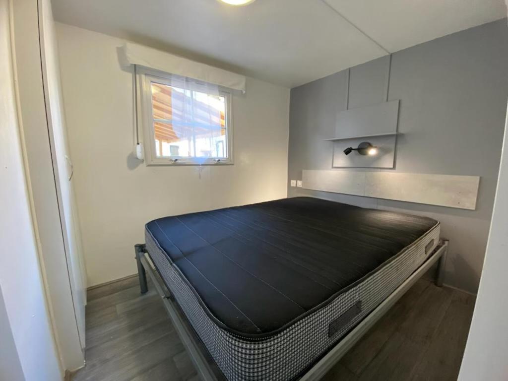 une chambre avec un grand lit dans une pièce dans l'établissement Mobil Home Bungalow Camping Sables D Or, au Grau-dʼAgde
