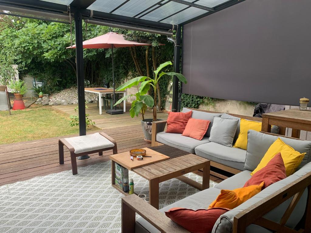 une terrasse avec moustiquaire, canapés et grand écran dans l'établissement Superbe T3- Two bedrooms appartment with garden and pétanque! Perfect Spot!, à Bordeaux