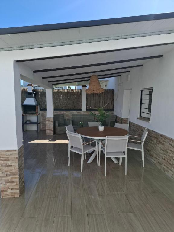 einen Essbereich mit einem Tisch und Stühlen sowie eine Küche in der Unterkunft CasaMaria 50 metros de la playa in El Palmar