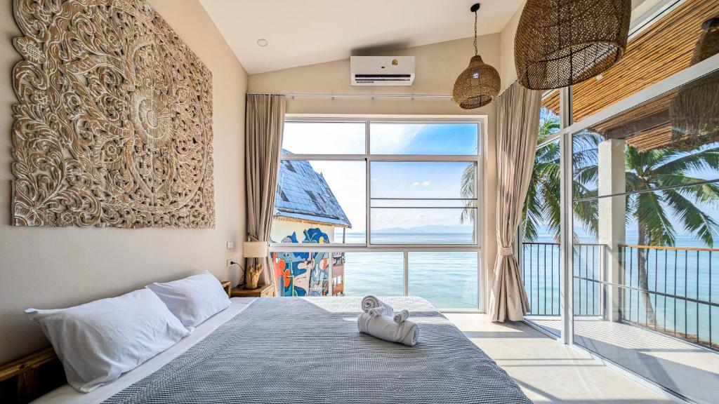 a bedroom with a bed and a large window at Happy Home kpg in Koh Phangan
