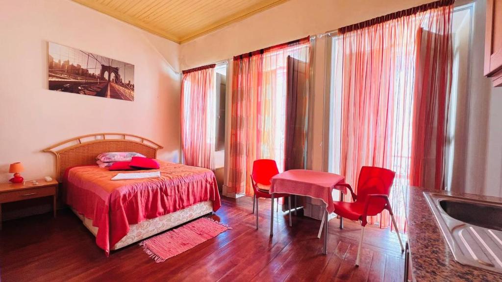a bedroom with a bed and a table and chairs at Ala do castelo hotel in Lagos