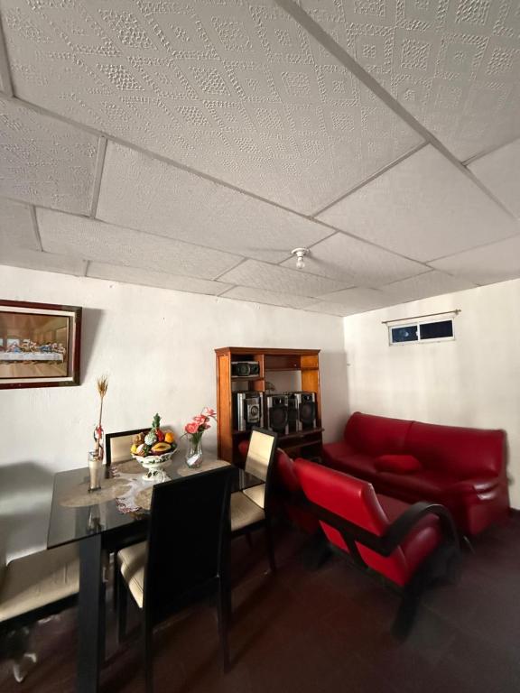 a living room with a red couch and a table at Casa de Ana in Malambo