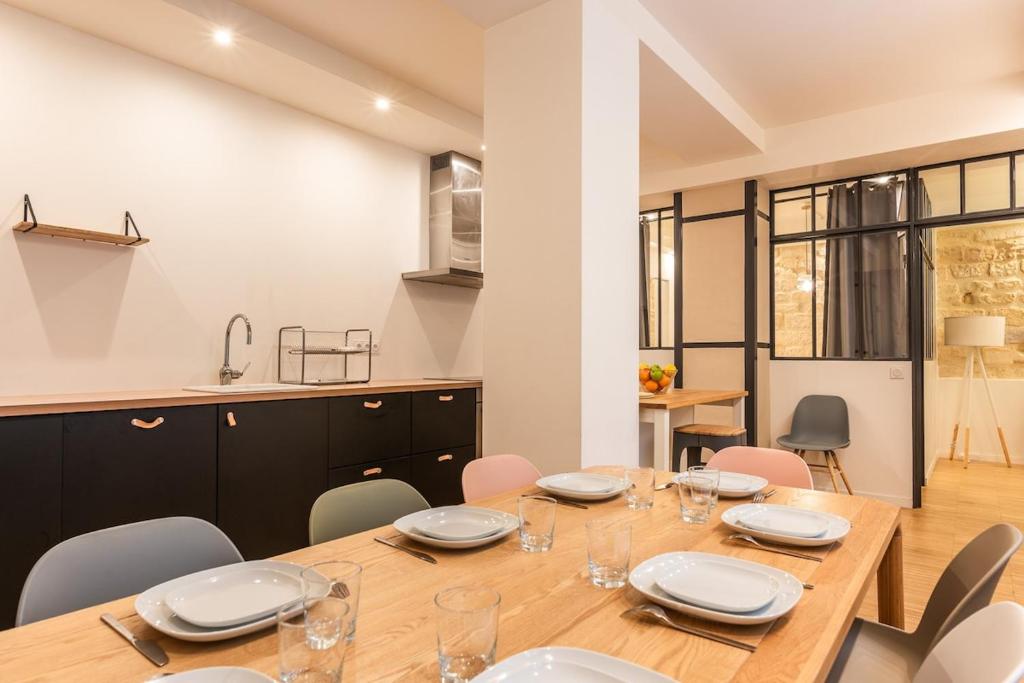 une salle à manger avec une table et des chaises en bois dans l'établissement Duplex Cinema I Luxe Collection, à Paris