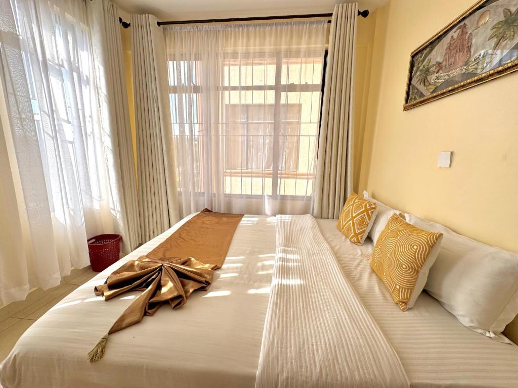 a large bed with a bow on it in a bedroom at Casa Bellà section 58 in Nakuru